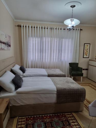 1 Schlafzimmer mit 2 Betten und einem Stuhl in der Unterkunft CIAK APARTMENT in Tirana