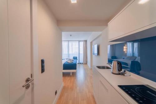 a kitchen and living room with a blue couch at Orbi City Luxury Resort in Batumi