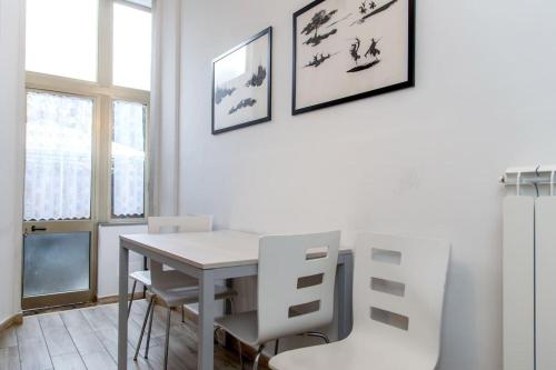 a white dining room with a table and chairs at Appartamento Cosimo in Florence