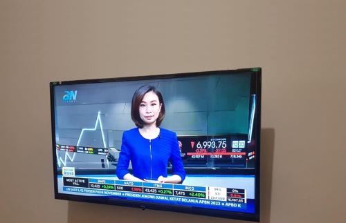 a television screen with a woman on it at Guest House GRIYA THAMRIN SYARIAH in Bonorejo