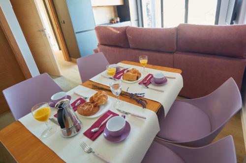 una mesa con platos de comida y copas de vino en HAVANAAPARTAMENTOS, en Puerto de Vega
