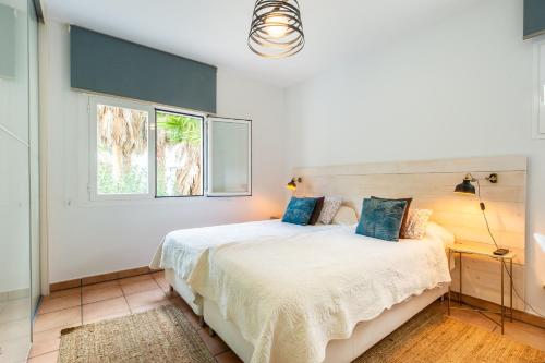 um quarto com uma cama e uma janela em Villa Blanca Santa Eulalia em Santa Eulária des Riu
