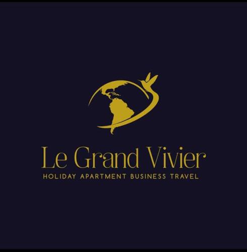 a gold logo with a bird flying around a globe at le Grand Vivier- 68 M2 in Héron