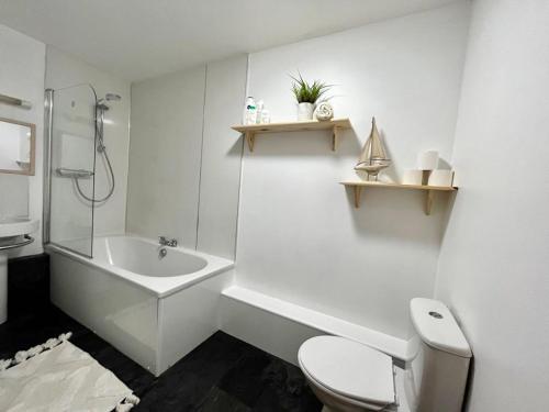 W łazience znajduje się toaleta, umywalka i wanna. w obiekcie Cosy City Centre Apartment w mieście Inverness