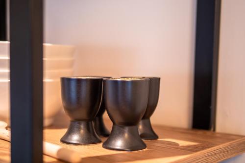 two silver cups sitting on a shelf in front of a mirror at Alte Bildhauerei in Aurach bei Kitzbuhel