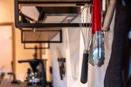 a kitchen utensils are hanging on a wall at Alte Bildhauerei in Aurach bei Kitzbuhel