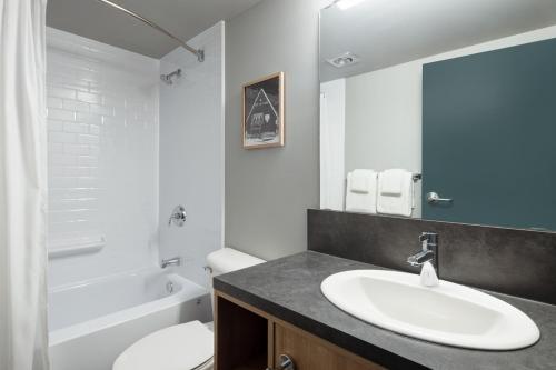 ein Badezimmer mit einem Waschbecken, einem WC und einer Badewanne in der Unterkunft The Approach Hotel in Panorama