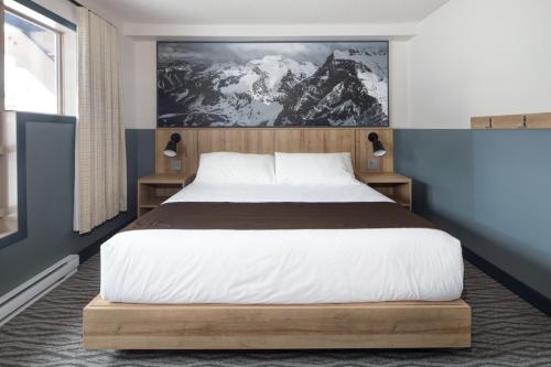 a bedroom with a large bed and a painting on the wall at The Approach Hotel in Panorama