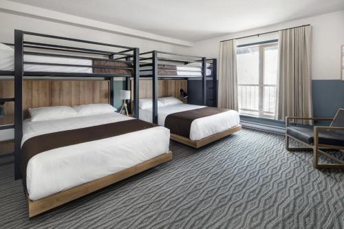 a hotel room with two beds and a chair at The Approach Hotel in Panorama
