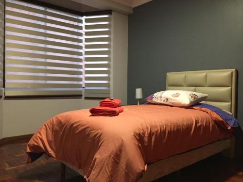 um quarto com uma cama com lençóis vermelhos e uma janela em Tu experiencia comienza aquí Departamento 3D 3C Achumani a pasos de la calle 29 em La Paz
