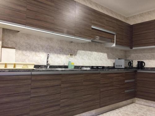 a kitchen with wooden cabinets and a sink at Tu experiencia comienza aquí Departamento 3D 3C Achumani a pasos de la calle 29 in La Paz