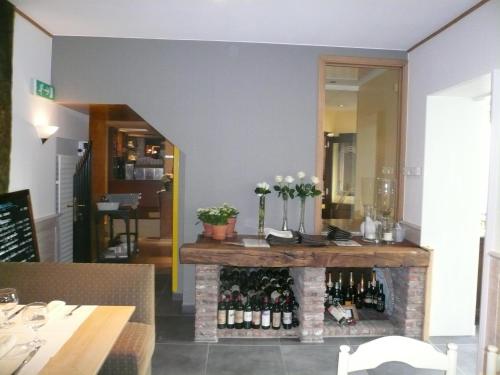 a room with a fireplace with bottles of wine at Hotel La Barakka in Lokeren