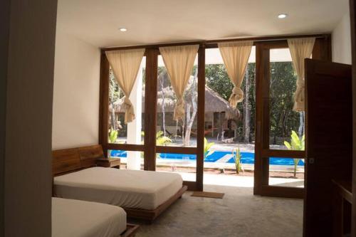 a bedroom with two beds and a view of a pool at Hanan Pacha in Macario Gomez