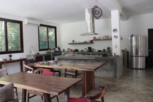 cocina con mesas de madera y fregadero en Hanan Pacha, en Macario Gomez