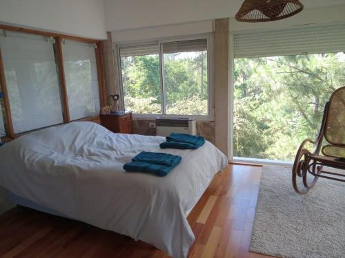 1 dormitorio con 1 cama con 2 toallas azules en Loft on Los Reartes River, Intiyaco en Villa Berna