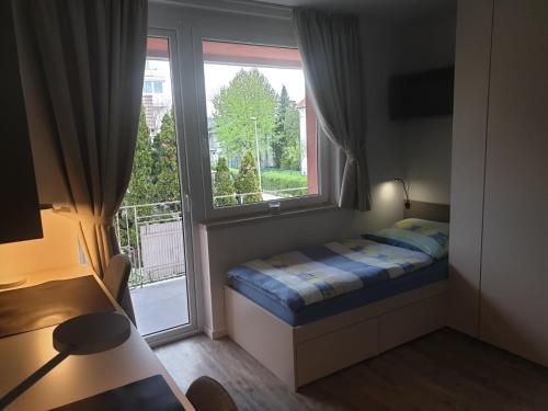 a small bedroom with a bed and a window at Apartma Vič Ljubljana in Ljubljana