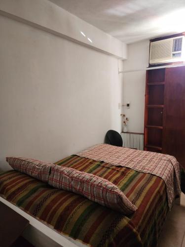 een slaapkamer met een bed met een kussen erop bij Sarmiento 1876 in Corrientes
