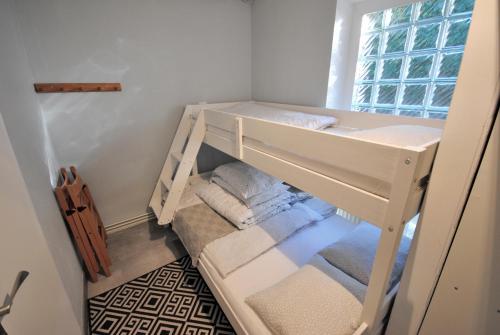 Cette petite chambre comprend des lits superposés blancs et des serviettes. dans l'établissement Willa Szyszka, à Karpacz