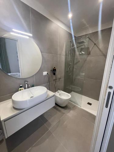 Un baño con lavabo blanco y ducha. en PALAZZO MAZZINI 2, en Caserta