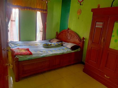 ein kleines Bett in einem Zimmer mit grünen Wänden in der Unterkunft Indo Hometown in Cireungit