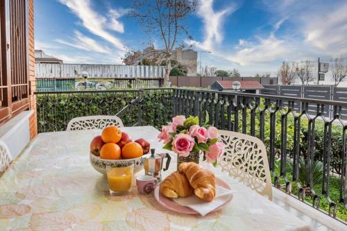una mesa con un bol de fruta y flores en el balcón en [Casa sul mare]+Posto auto+Giardino+WiFi, en Terracina