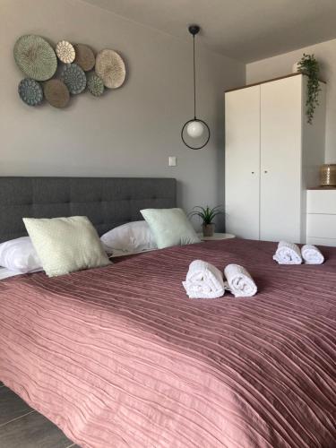 a bedroom with a large bed with three pillows on it at Balkon Apartmanház Panzió in Balatonfüred
