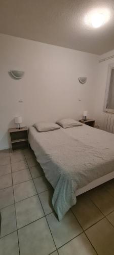 a bedroom with a bed and two night stands on the floor at Residence T2 du Golf de Digne in Digne-les-Bains