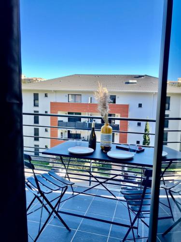 - un balcon avec une table et des chaises dans l'établissement Bastia sud , Quartier residentiel, à Bastia