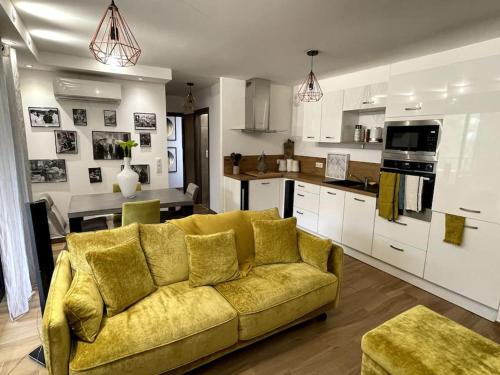 ein Wohnzimmer mit einer gelben Couch in einer Küche in der Unterkunft Appartement calme proche Bastia in Cardo