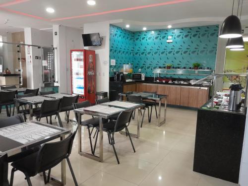 a dining room with tables and chairs in a restaurant at Mais Hotel Express in São Luís