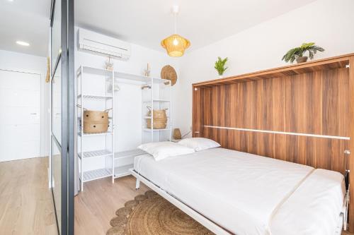 una camera con letto e testiera in legno di Cachirulo Deluxe Apartment 13-B Levante Beach a Benidorm