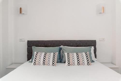 a bedroom with a white bed with two pillows at Pura Vida Terraza Vistas Mar y Montaña, Piscina, Parking by Vero in Altea la Vieja