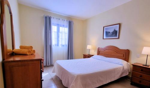 a bedroom with a bed and a dresser and a window at La Graciosa Camelia Beach Vistas Mar in Caleta de Sebo