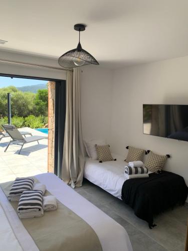 a bedroom with a bed and a large window at DOMAINE NAPOLEON CORSICA FIGARI in Figari