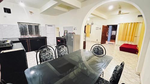 a dining room with a table and chairs in a kitchen at Muffys Guest House in Arpora