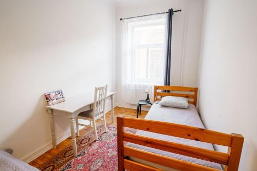 een slaapkamer met een bureau, een bed en een tafel bij Two bedroom Ausekla apartment in Liepāja