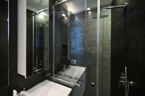 a bathroom with a shower with a sink and a mirror at Modern 2BR Condo with Sea Views at Isrotel by HolyGuest in Tel Aviv