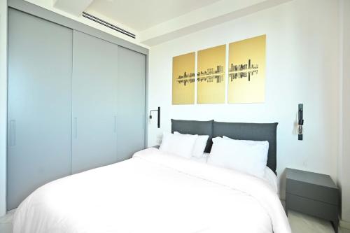 a bedroom with a white bed with white pillows at Modern 2BR Condo with Sea Views at Isrotel by HolyGuest in Tel Aviv