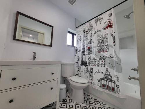 La salle de bains est pourvue de toilettes, d'un lavabo et d'un miroir. dans l'établissement Rockland Villa - Huge in the epicenter of Miami, à Miami