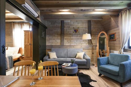 a living room with a couch and a bed at Ethno Houses Plitvice Lakes Hotel in Plitvica selo
