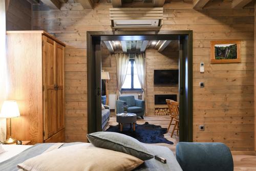 a bedroom with a bed and a living room at Ethno Houses Plitvice Lakes Hotel in Plitvica selo