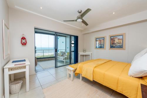 a bedroom with a yellow bed and a balcony at INDIGO BAY 24 in Margate