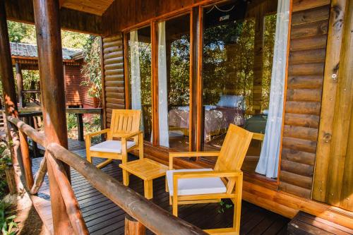 a porch of a cabin with chairs and windows at Cabañas complejo Ysyry Misiones in Puerto Victoria