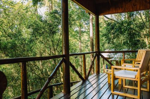 a screened in porch with two chairs and trees at Cabañas complejo Ysyry Misiones in Puerto Victoria