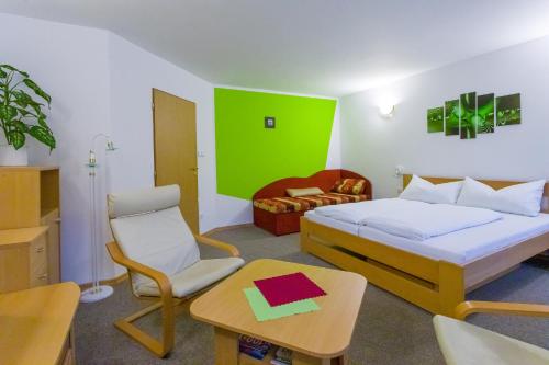 a bedroom with a bed and a chair and a table at Pension Kraus in Litomyšl