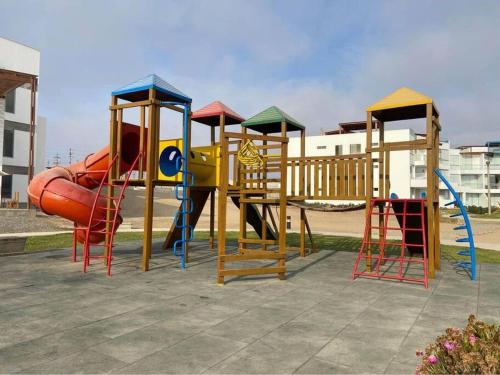 a playground with a slide and a slideintend at A 3 minutos de la Playa Hermoso Departamento con Piscina y Parrilla in Asia