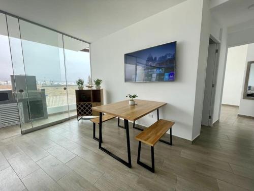 a dining room with a wooden table and a bench at A 3 minutos de la Playa Hermoso Departamento con Piscina y Parrilla in Asia