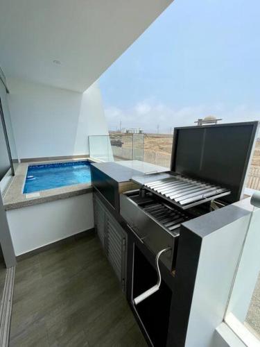 a kitchen with a swimming pool in a house at A 3 minutos de la Playa Hermoso Departamento con Piscina y Parrilla in Asia