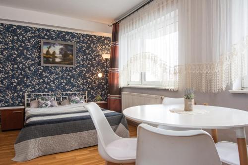 a bedroom with a bed and a table and chairs at ADA - pokoje gościnne in Łeba