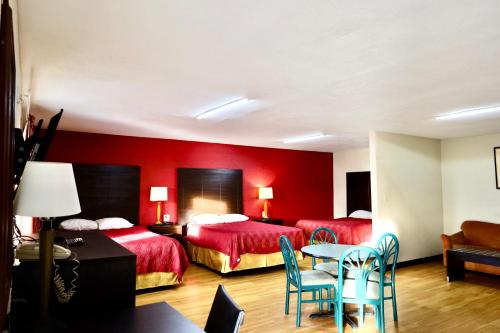 a hotel room with two beds and a table and chairs at Rodeway Inn in Pauls Valley